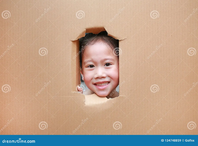 Happy asian kid girl looking hole cardboard copy space 134748859